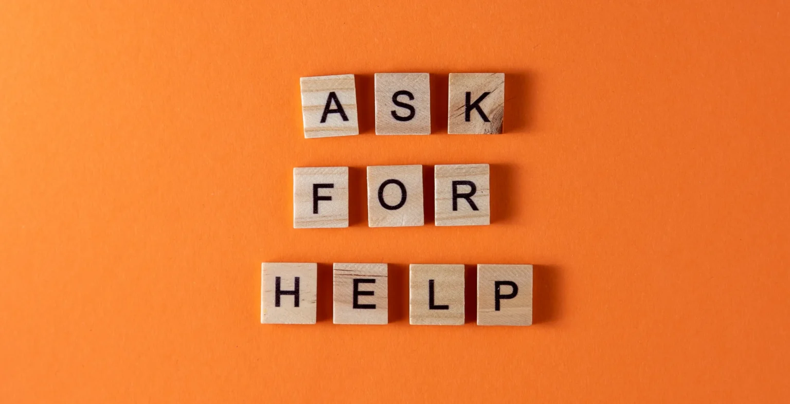 Wooden tiles spelling Ask For Help: contact a Toronto charity, W1derus Foundation