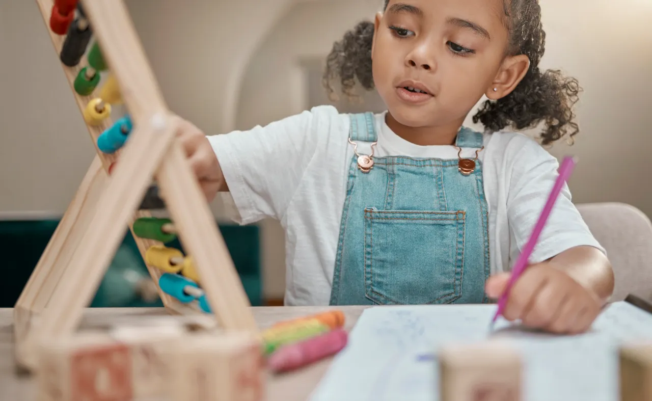 Young girl learning with an abacus: PROPS for People community programs in Toronto